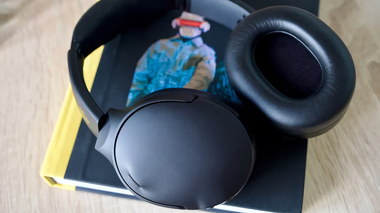 Кітап үстінде жатқан Skullcandy Crusher 1080 құлаққабы